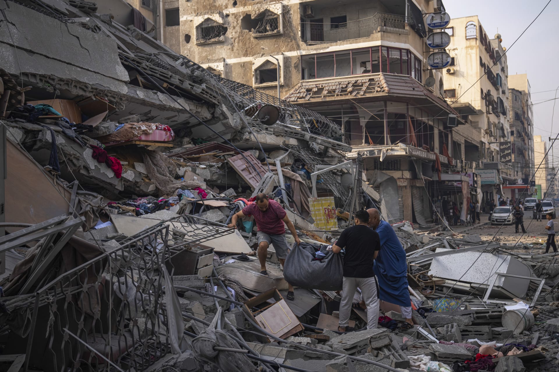 Palestinci prohledávají sutiny budovy zasažené při izraelském leteckém útoku v Gaze.