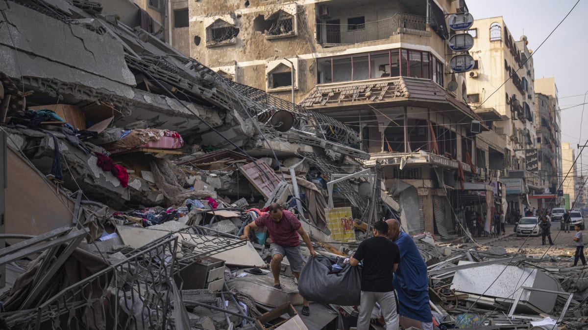 Palestinci prohledávají sutiny budovy zasažené při izraelském leteckém útoku v Gaze (8.10.2023)