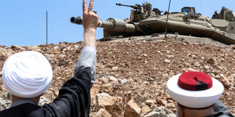Libanonští muslimští duchovní gestikulují směrem k izraelskému tanku Merkava