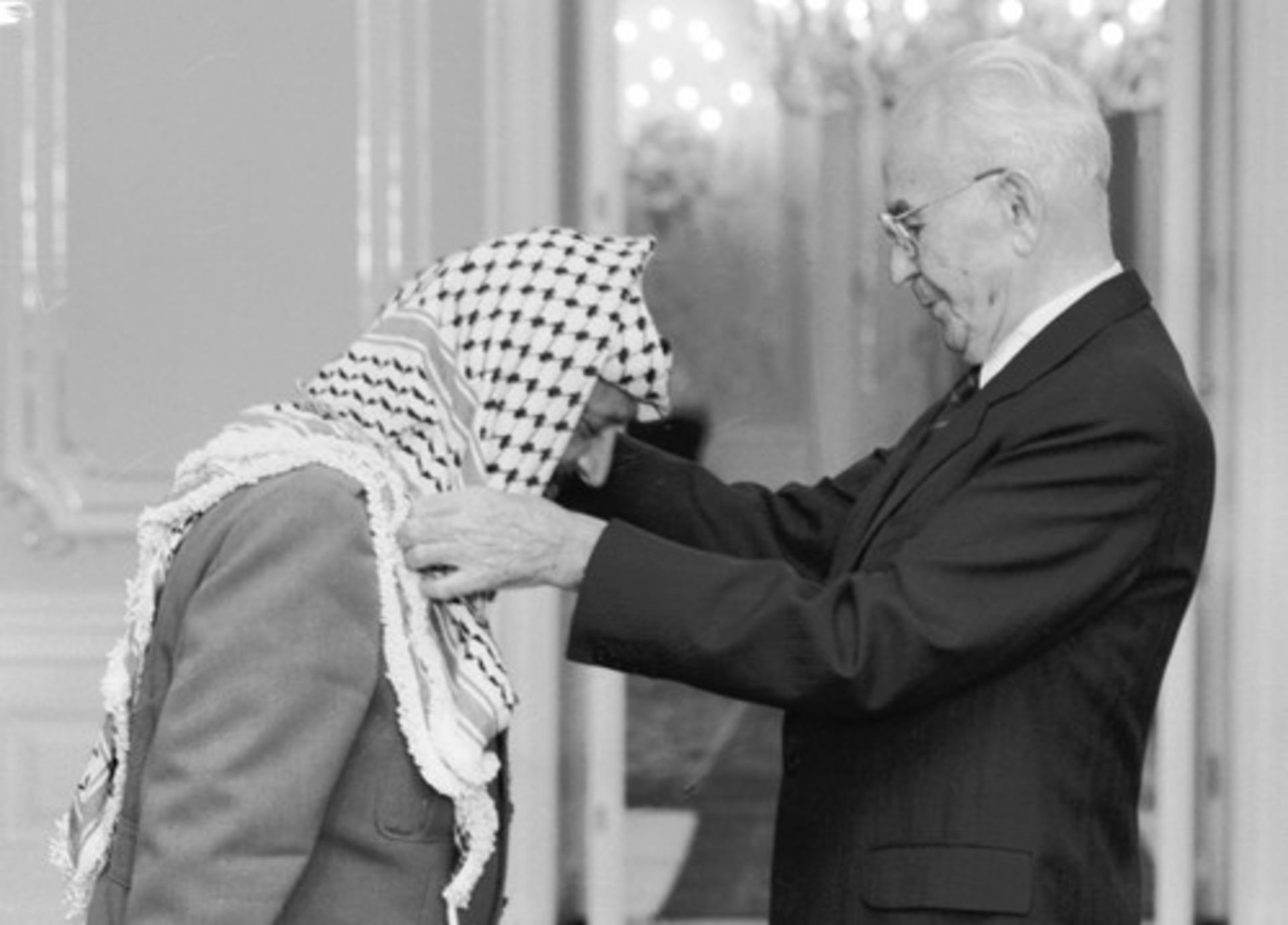 Návštěva Jásira Arafata v Praze, 18. října 1989. Do Československa tehdy přijel i Bassam Abu Sharif, podle amerického časopisu Time nejznámější tvář palestinského teroru. Prezident ČSSR Gustáv Husák (vpravo) předal na Pražském hradě předsedovi výkonného výboru OOP Jásiru Arafatovi Československý řád Bílého lva I. třídy.