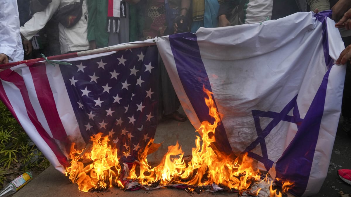 Muslimští demonstrati v indonéské Jakartě pálí americké a izraelské vlajky v reakci na odvetné útoky Jeruzaléma v Gaze (11. 10. 2023).