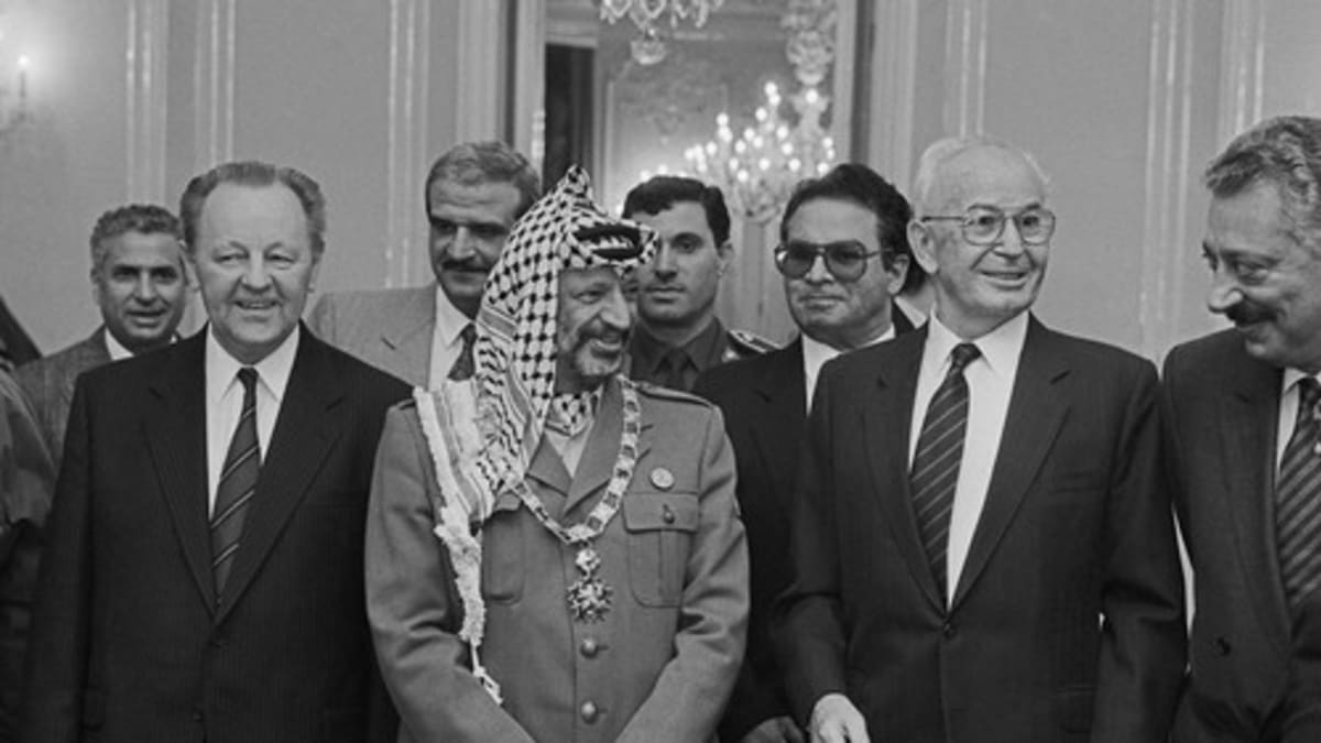návštěvě Jásira Arafata v Praze, 18. října 1989. Do Československa tehdy přijel i Bassam Abu Sharif (s brýlemi za Husákem), podle amerického časopisu Time nejznámější tvář palestinského teroru.