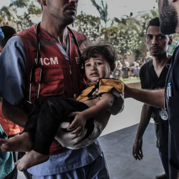 Zdravotník v Gaze vnáší poraněné dítě do nemocnice (13. 10. 2023).