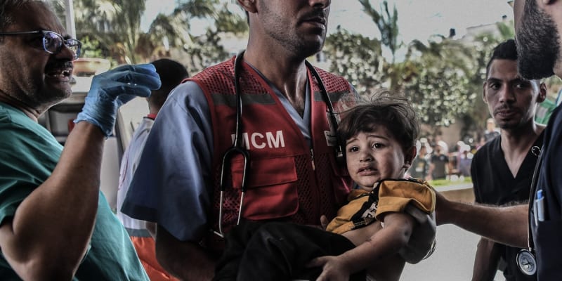 Zdravotník v Gaze vynáší poraněné dítě do nemocnice.