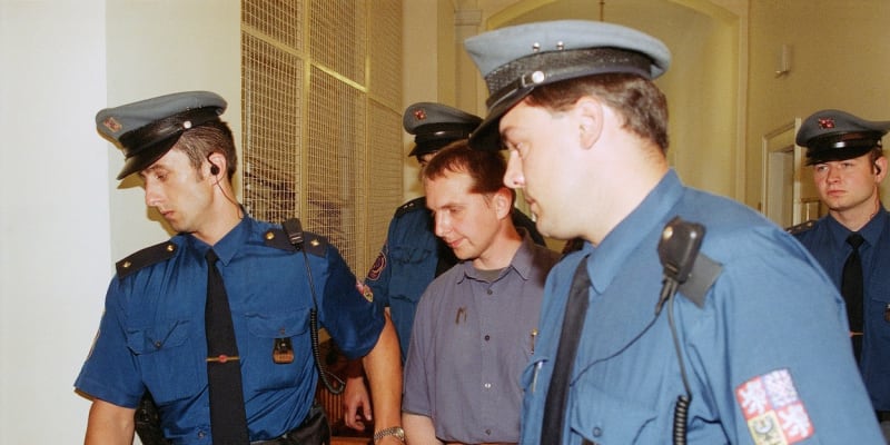 Justiční stráž přivádí pětinásobného vraha Ludvíka Černého do jednací síně Městského soudu v Praze