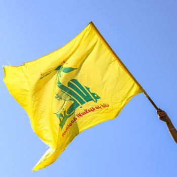 Demonstrant v ulicích Bejrútu s vlajkou Hizballáhu