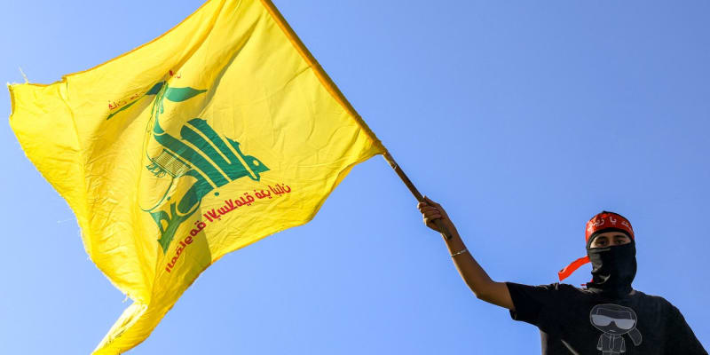 Demonstrant v ulicích Bejrútu s vlajkou Hizballáhu