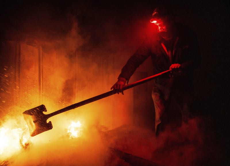 Jeden z místních obyvatel bojuje s plameny na svém pozemku (30. 10. 2023).