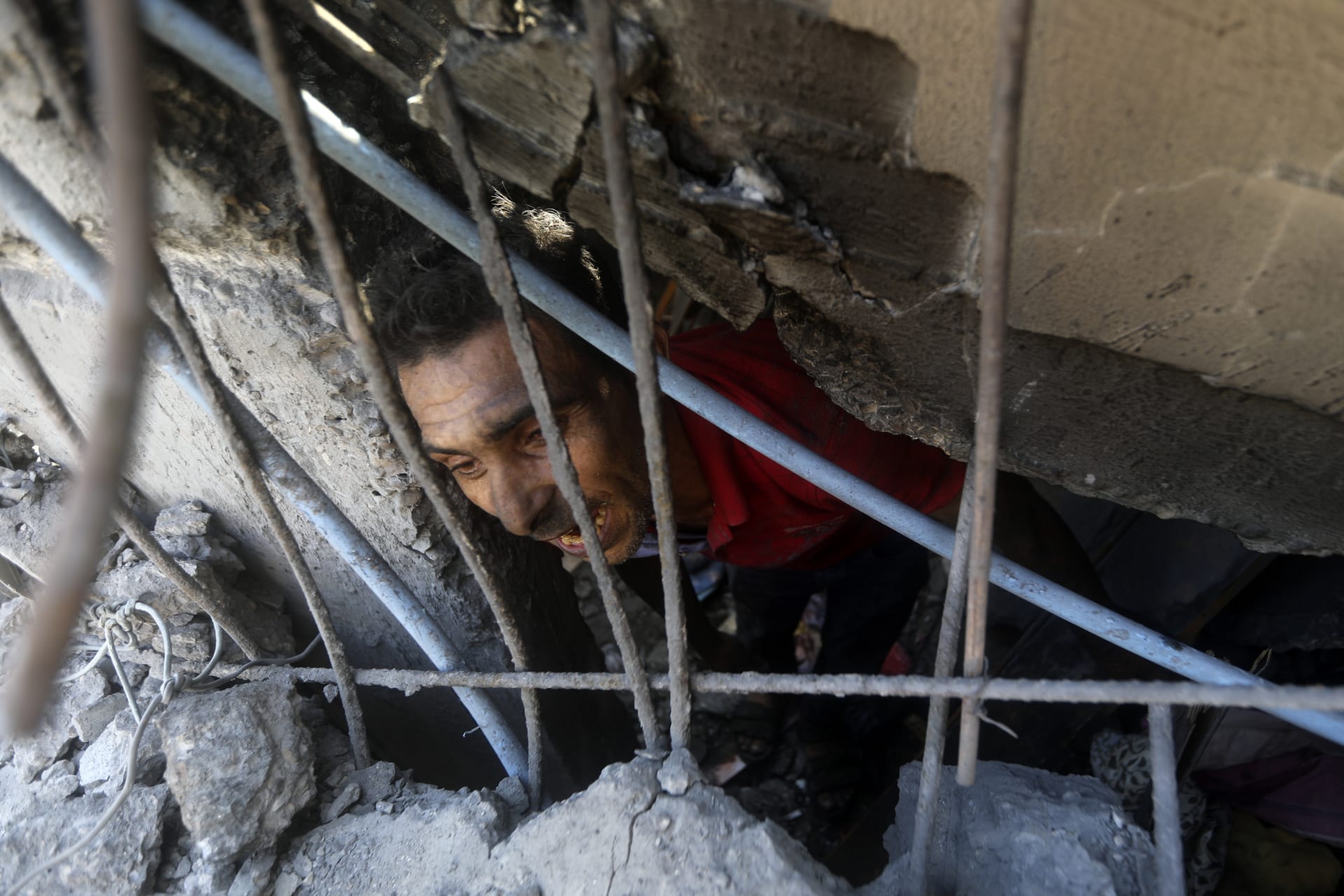 Palestinský muž v troskách budovy, kterou ve městě Chán Júnis zasáhl izraelský nálet 