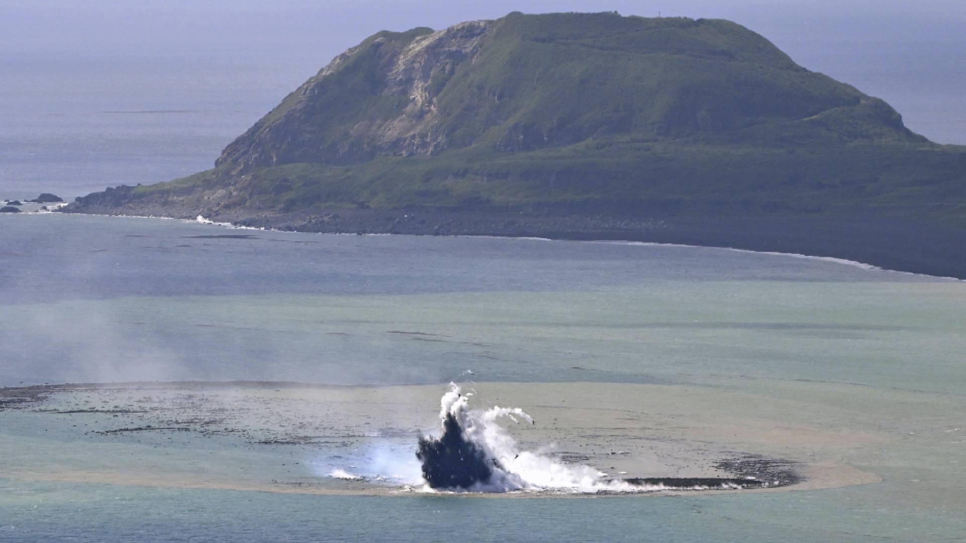 Poblíž Iwodžimy se z moře vynořil nový ostrov. V pozadí hora Suribači, o kterou sváděli Američané na jaře 1945 tvrdé boje s Japonci