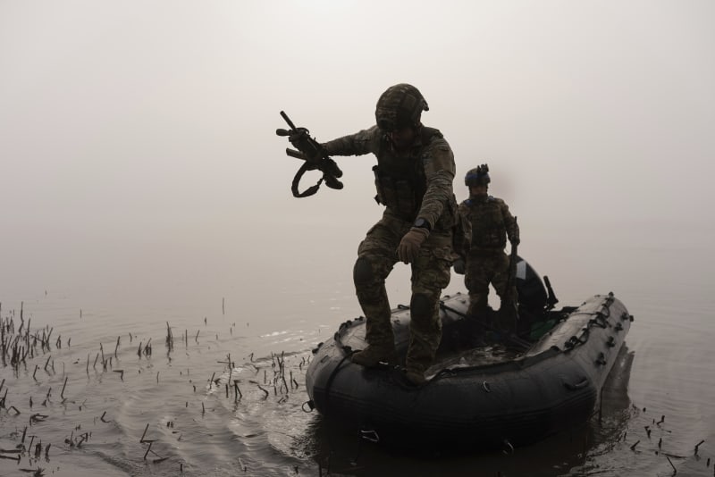Ukrajinští vojáci plavící se na člunu přes řeku Dněpr nedaleko frontové linie