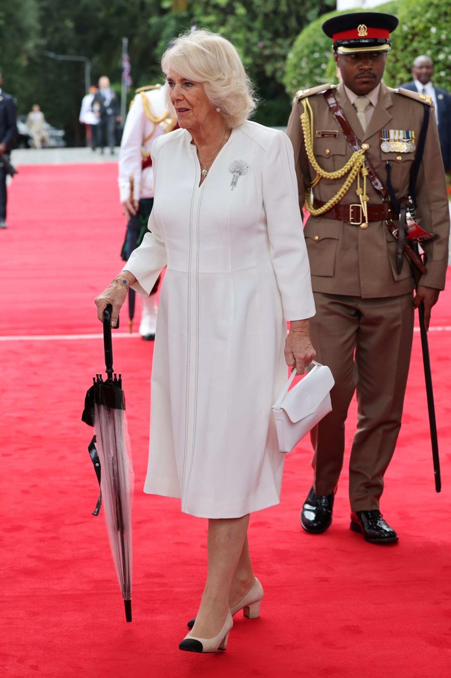 Královna Camilla si ozdobila broží bílé elegantní šaty.