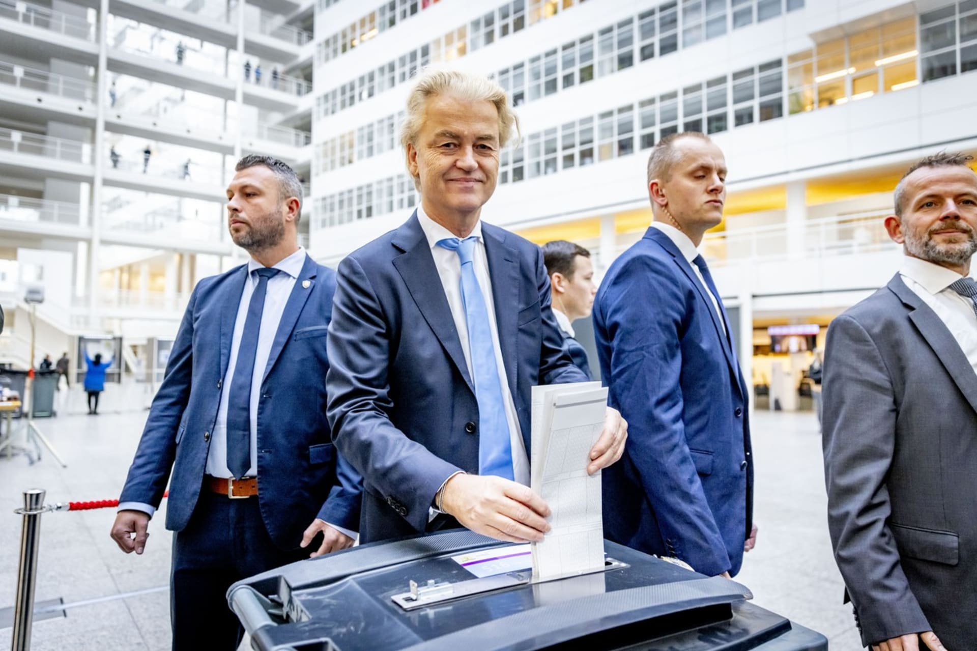 Geert Wilders v doprovodu dvou bodyguardů vhazuje volební lístek.