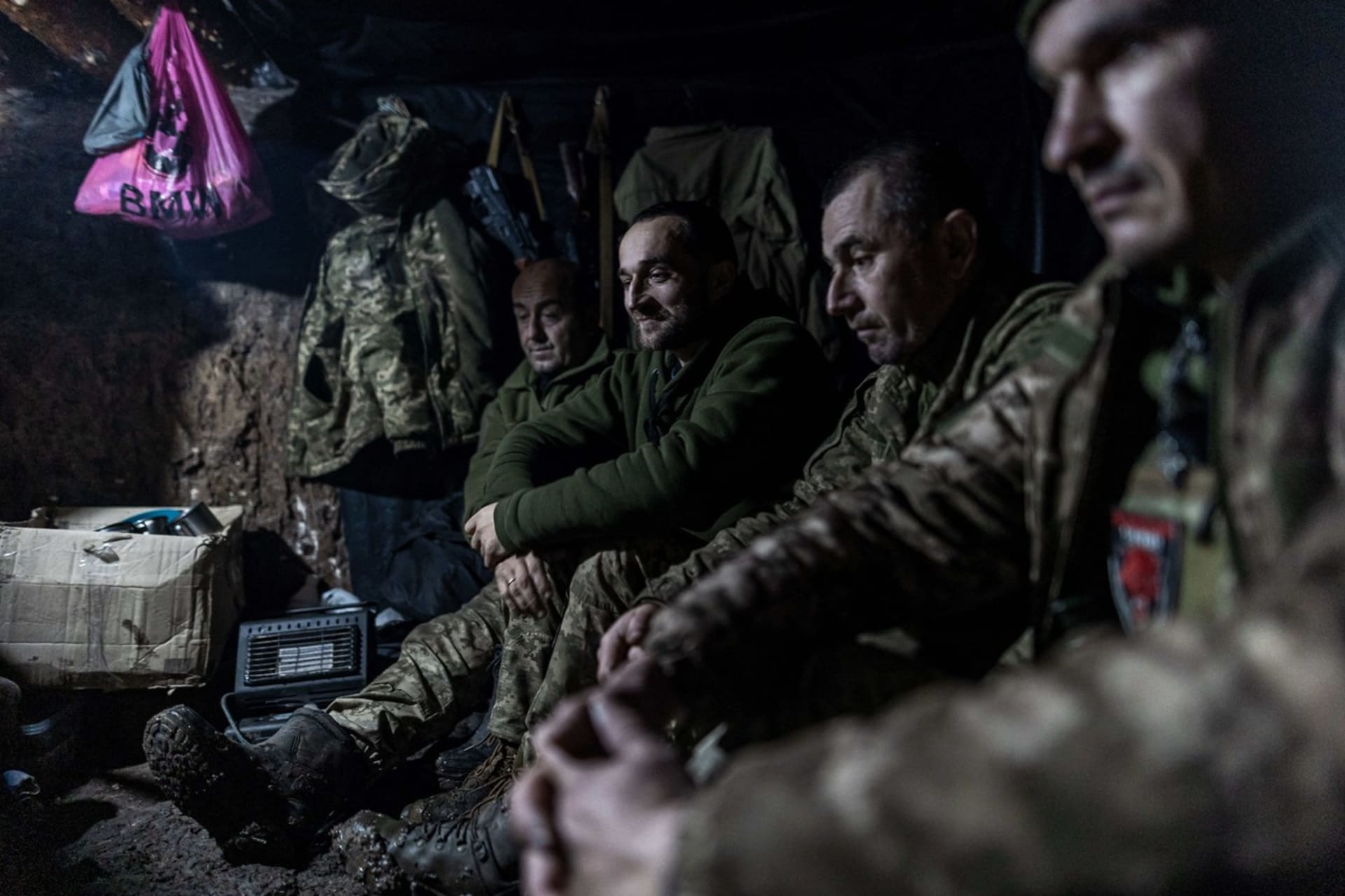 Ukrajinští vojáci sedí v krytu u frontové linie nedaleko Charkova