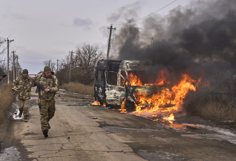 Ukrajinští vojáci z 10. samostatné horské útočné brigády „Edelweiss“ míjí u Bachmutu hořící vozidlo, které zasáhl ruský dron