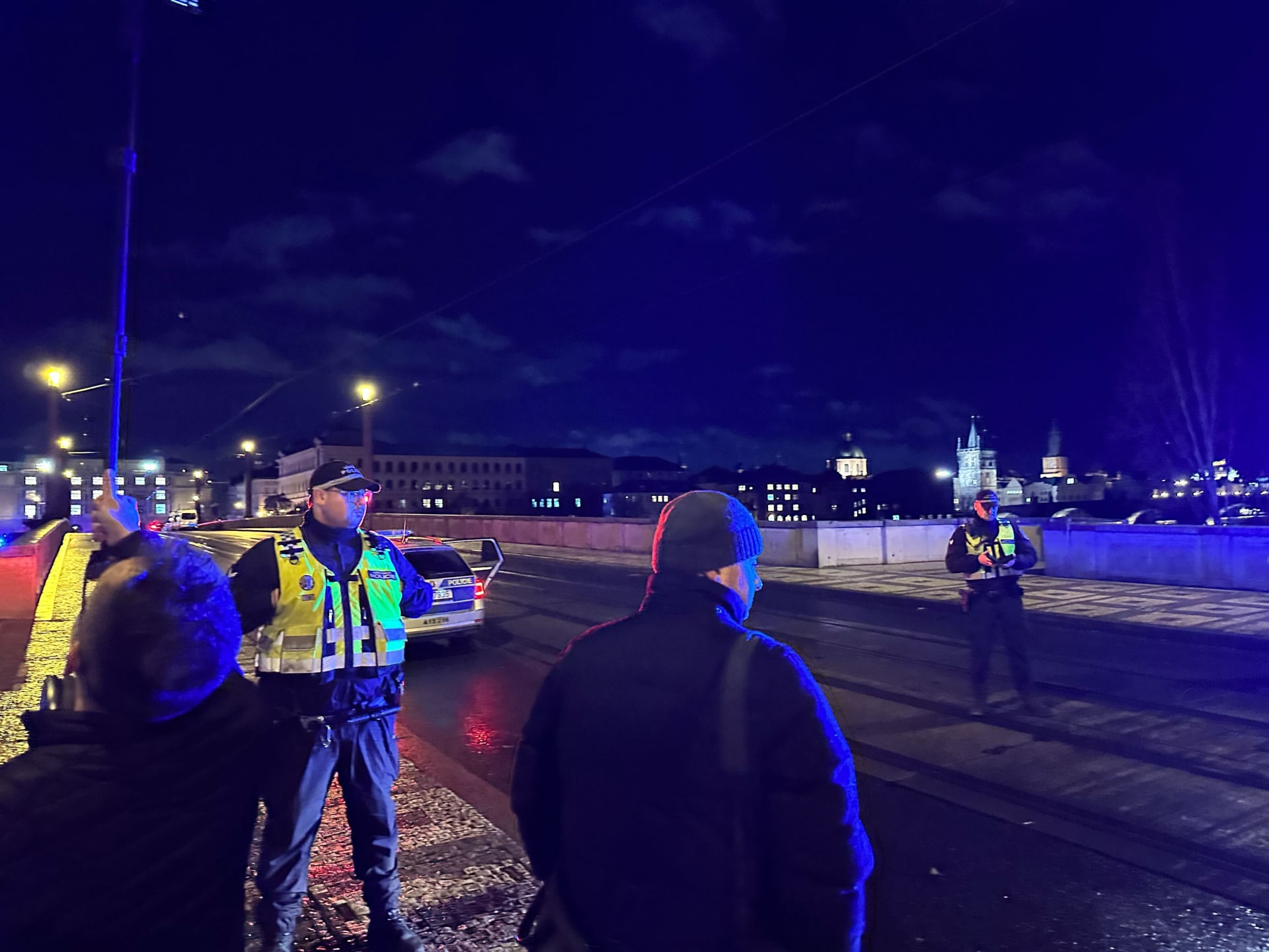 Policisté a novináři poblíž budovy Filozofické fakulty UK v Praze krátce po útoku