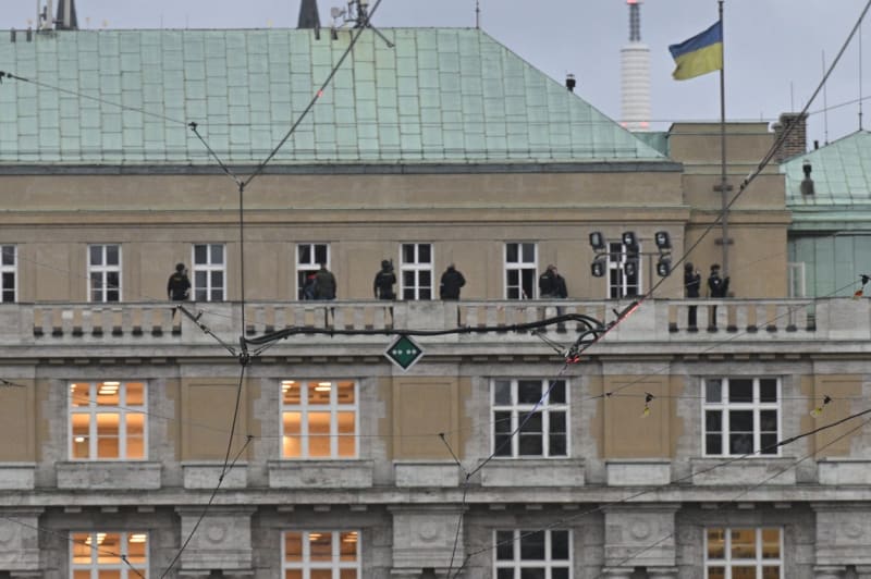 Policisté zasahují na střeše budovy Filozofické fakulty, ve které se střílelo, 21. prosince 2023, Praha.