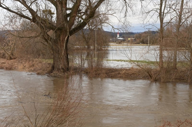 Rozvodněná řeka Morava a zaplavené louky u silnice 2. třídy číslo 444 z Mohelnice do Úsova na Šumpersku, 25. prosince 2023. V pozadí je obec Třeština.