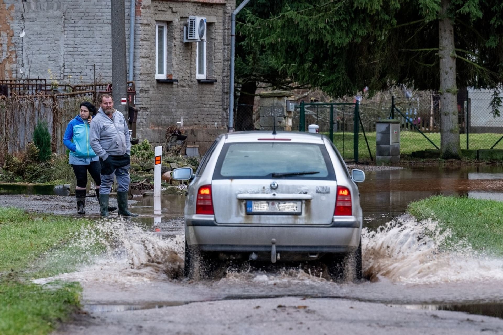 Automobil projíždí po silnici zaplavenou vodou z rozvodněné řeky Labe v Brodě.