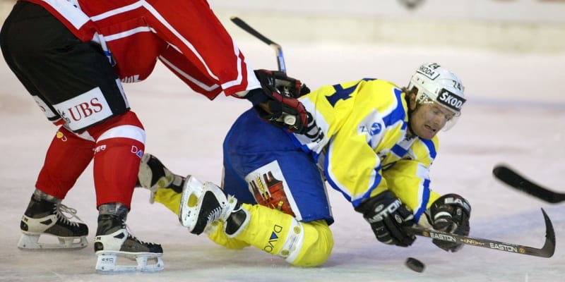Kanadský hráč Reggie Savage sráží na led českého útočníka HC Davos Josefa Marhu v utkání Spenglerova poháru.