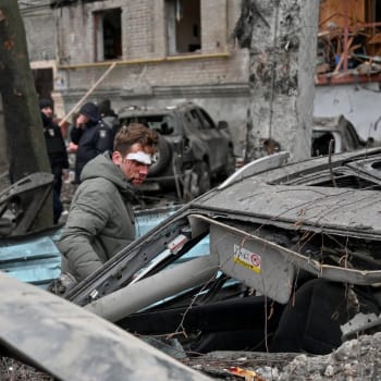 Zraněný místní obyvatel si prohlíží své zničené auto před obytným domem v centru Charkova po raketovém útoku 2. ledna 2024 uprostřed ruské invaze na Ukrajinu. 