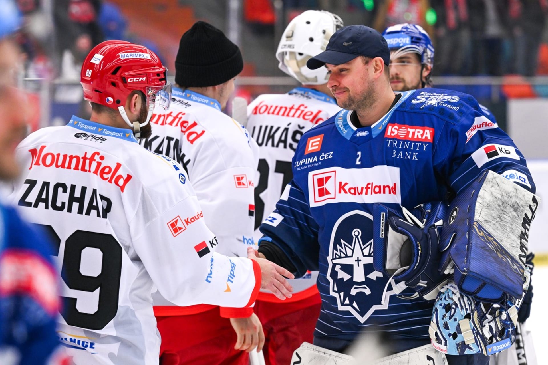 Slovenský hokejový brankář Julius Hudáček v dresu extraligového Kladna si podává ruce se soupeři z Hradce Králové.