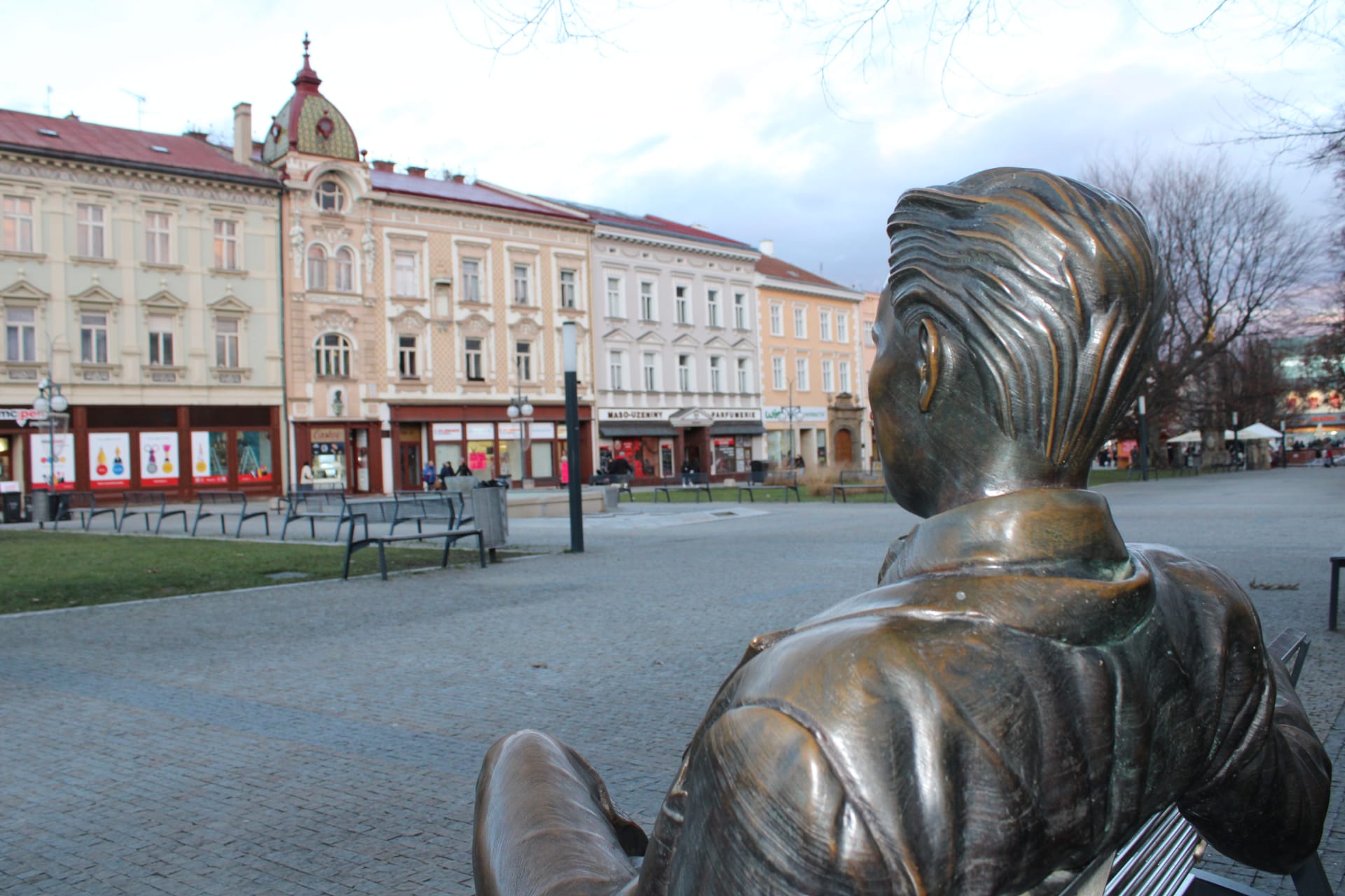 Bronzový básník Jiří Wolker na náměstí v Prostějově. Upřeně se dívá na rodný dům, ve kterém i zemřel, a z něhož v sobotu 5. ledna 1924 také vyšel pohřební průvod s básníkovou rakví.