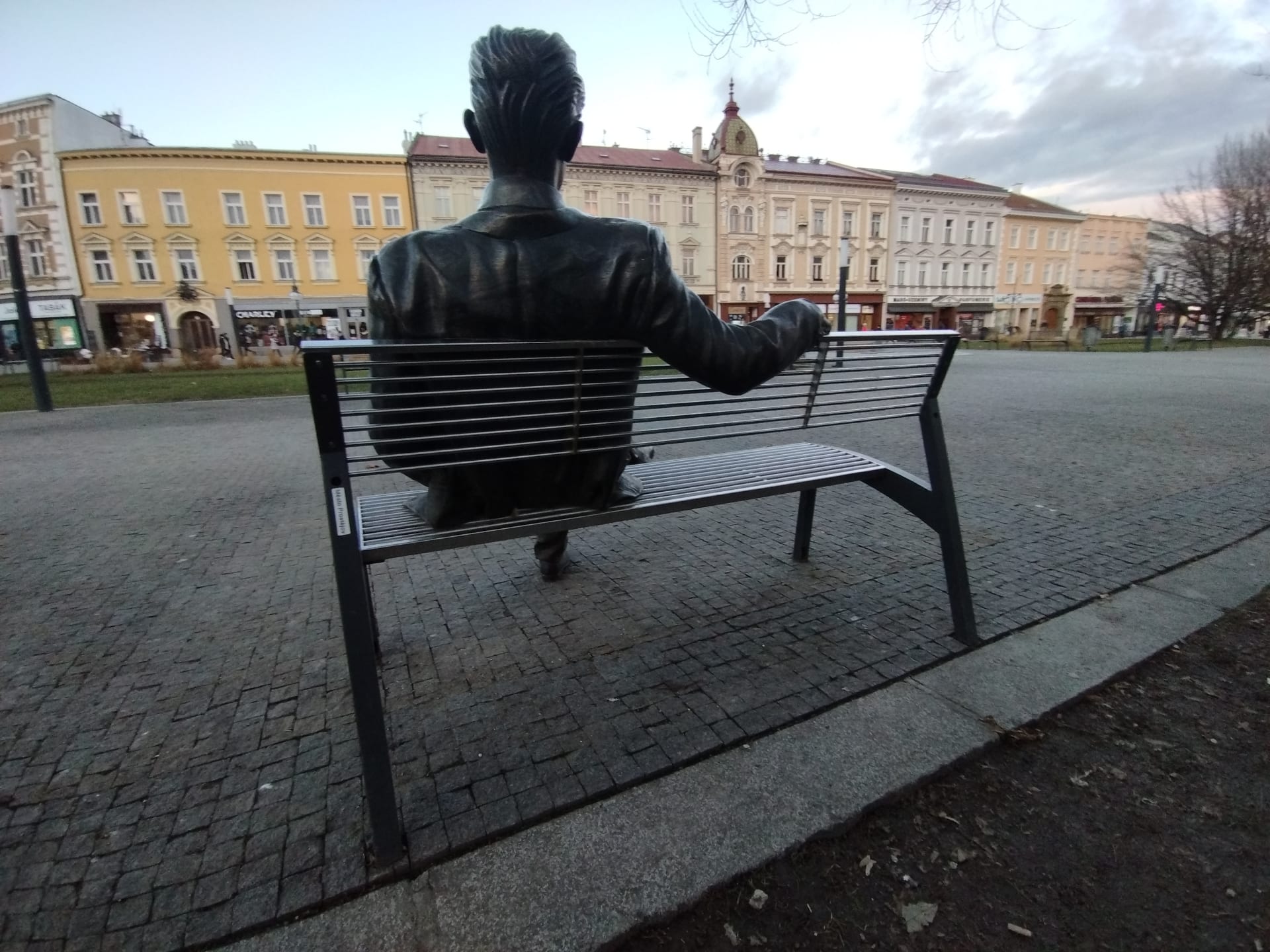 Bronzový básník Jiří Wolker na náměstí v Prostějově. Upřeně se dívá na rodný dům, ve kterém i zemřel, a z něhož v sobotu 5. ledna 1924 také vyšel pohřební průvod s básníkovou rakví. 