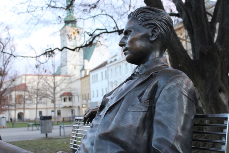 Bronzový básník Jiří Wolker na náměstí v Prostějově. Upřeně se dívá na rodný dům, ve kterém i zemřel, a z něhož v sobotu 5. ledna 1924 také vyšel pohřební průvod s básníkovou rakví.