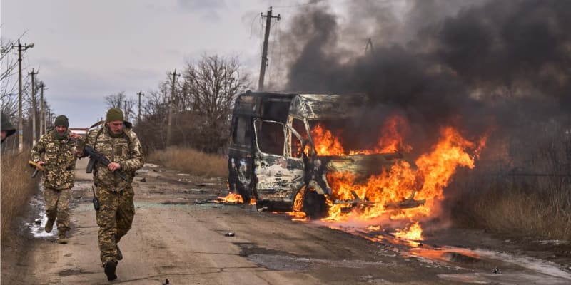 Ukrajinští vojáci z 10. samostatné horské útočné brigády „Edelweiss“ míjí u Bachmutu hořící vozidlo, které zasáhl ruský dron.