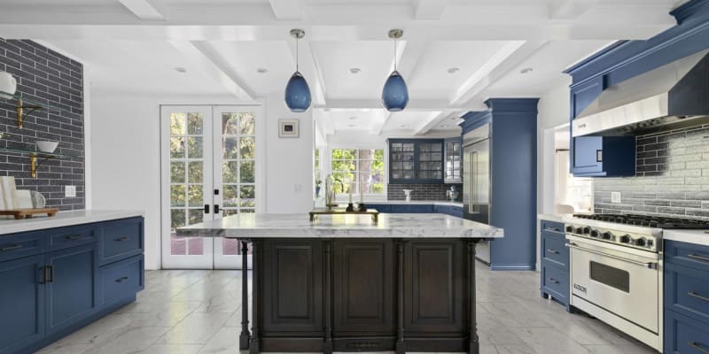 Dům, kde bydlel Paul Newman a Joanne Woodwardová v Beverly Hills: kuchyň má středový ostrůvek a tmavě modře lakované skříňky