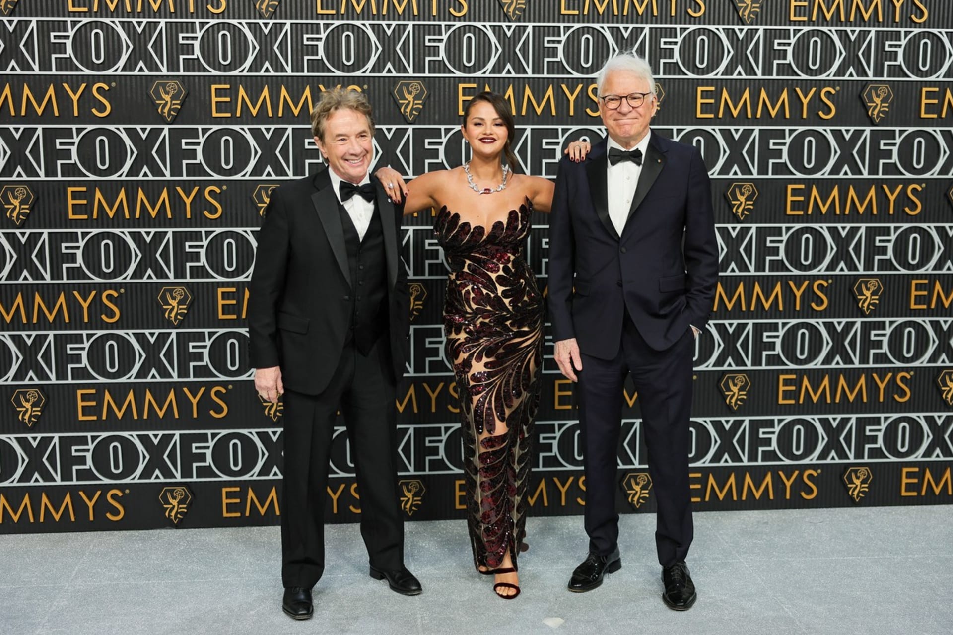 Martin Short a Steve Martin pózují po boku své kolegyně ze seriálu Jen vraždy v budově Seleny Gomezové, která si oblékla šaty Oscar de la Renta.
