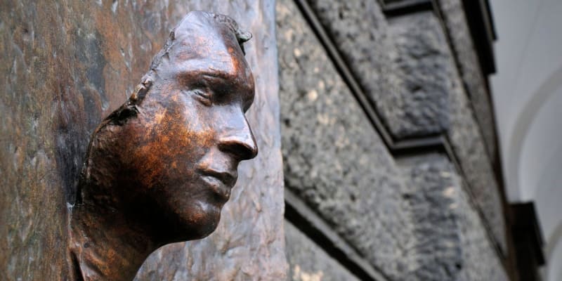 Odlitek posmrtné masky Jana Palacha na budově Filozofické fakulty v Praze