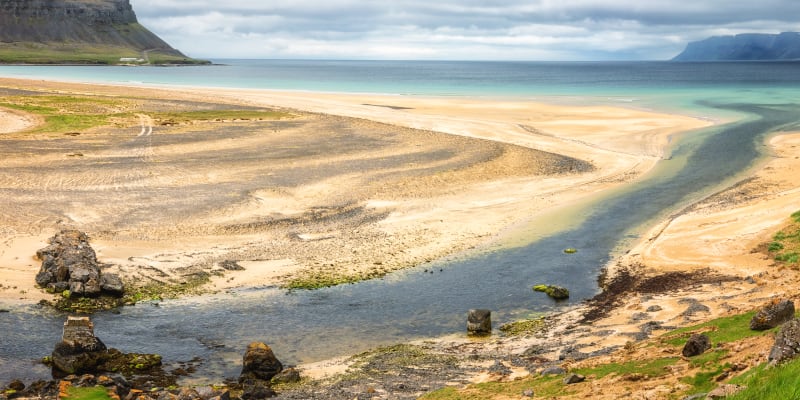 Pláž Rauasandur na Islandu je známá svým zlatým pískem. Někdy mívá i červenou či růžovou barvu.