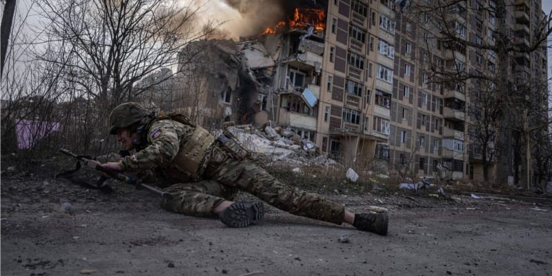 Ukrajinský voják se kryje v Avdijivce po ruském útoku (17. 3. 2023).