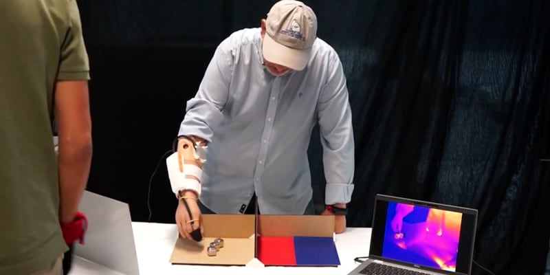 Muž 37 let po amputaci testuje protézu ruky, díky níž znovu vnímá teplotu. Na snímku rozděluje horké a studené kostky v časovém limitu.
