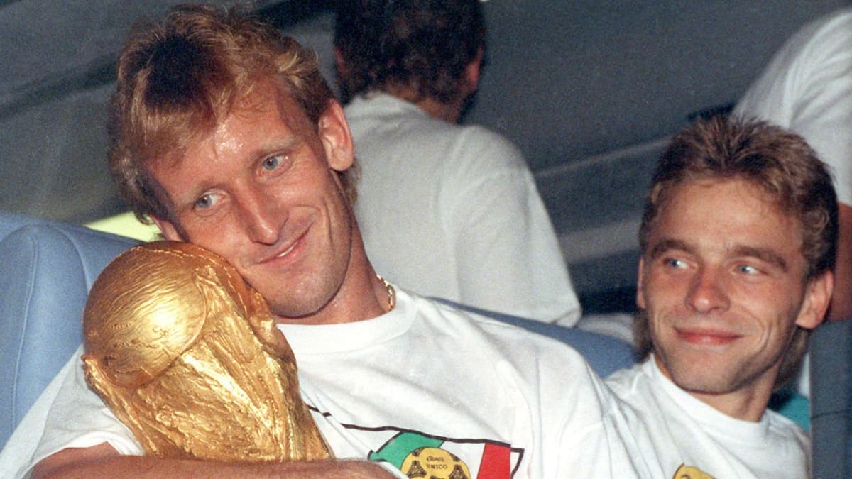 Německý fotbalový reprezentant Andreas Brehme s mistrovským pohárem a jeho spoluhráč Thomas Haessler v italském Římě (9. červenec 1990)
