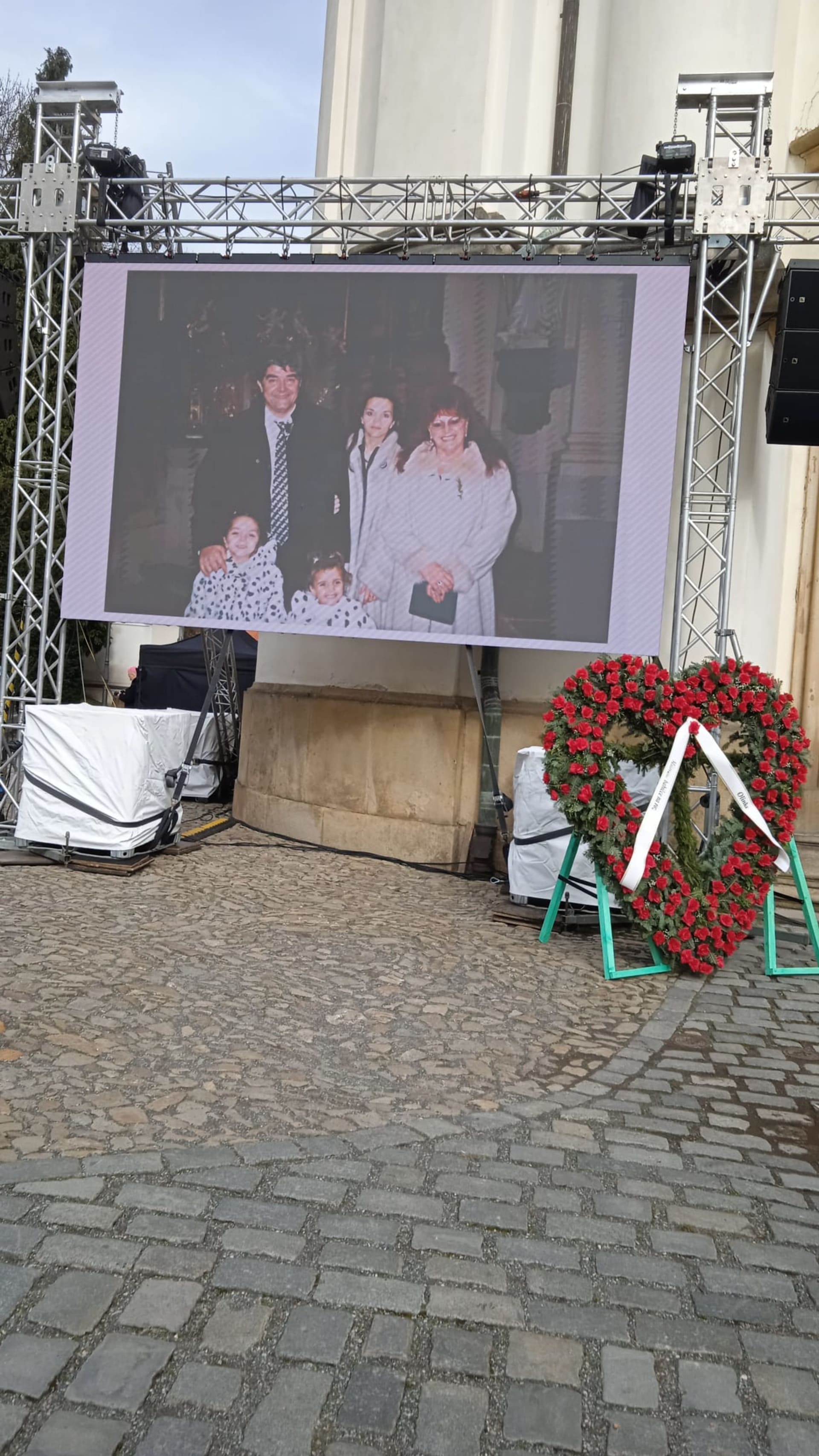 Na plátně před kostelem se promítají fotografie ze života Olgy Kočkové.