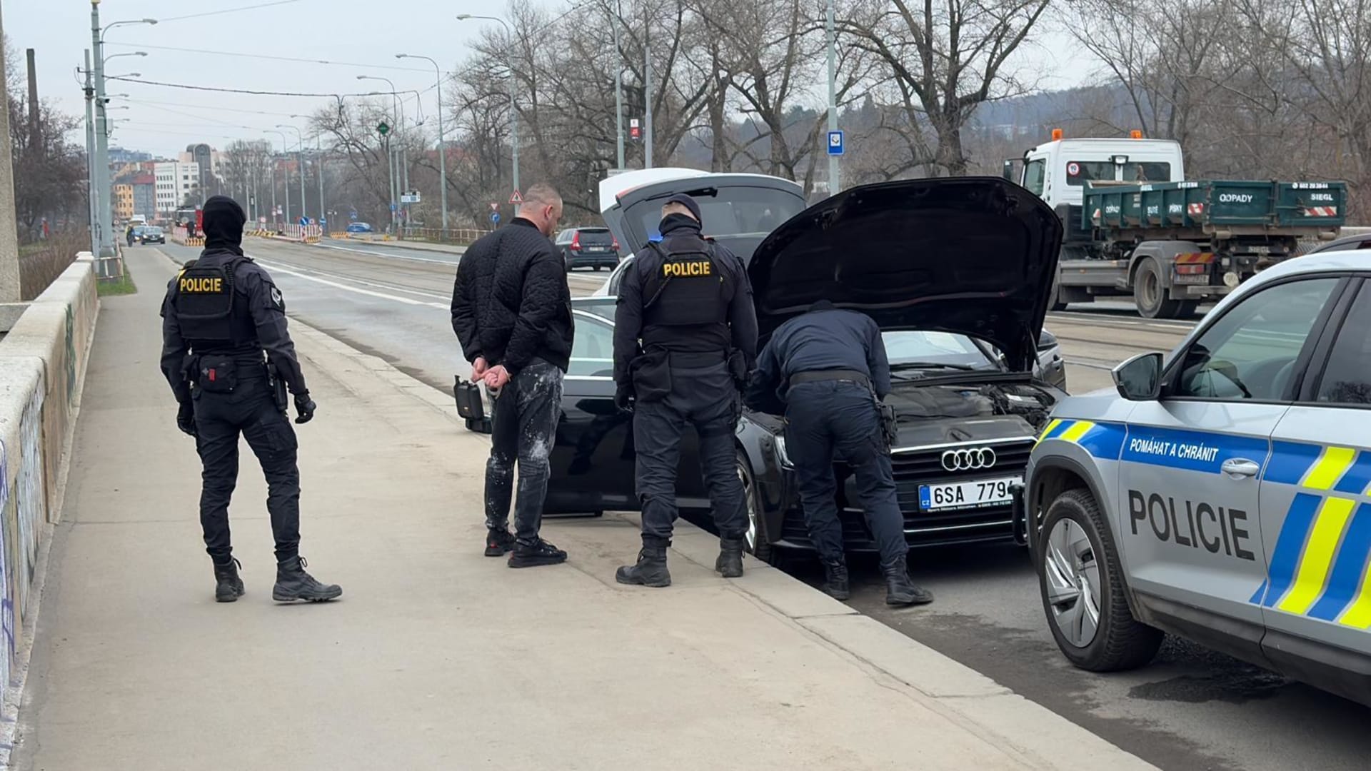 Policisté prohledávají auto na Libeňském mostě.