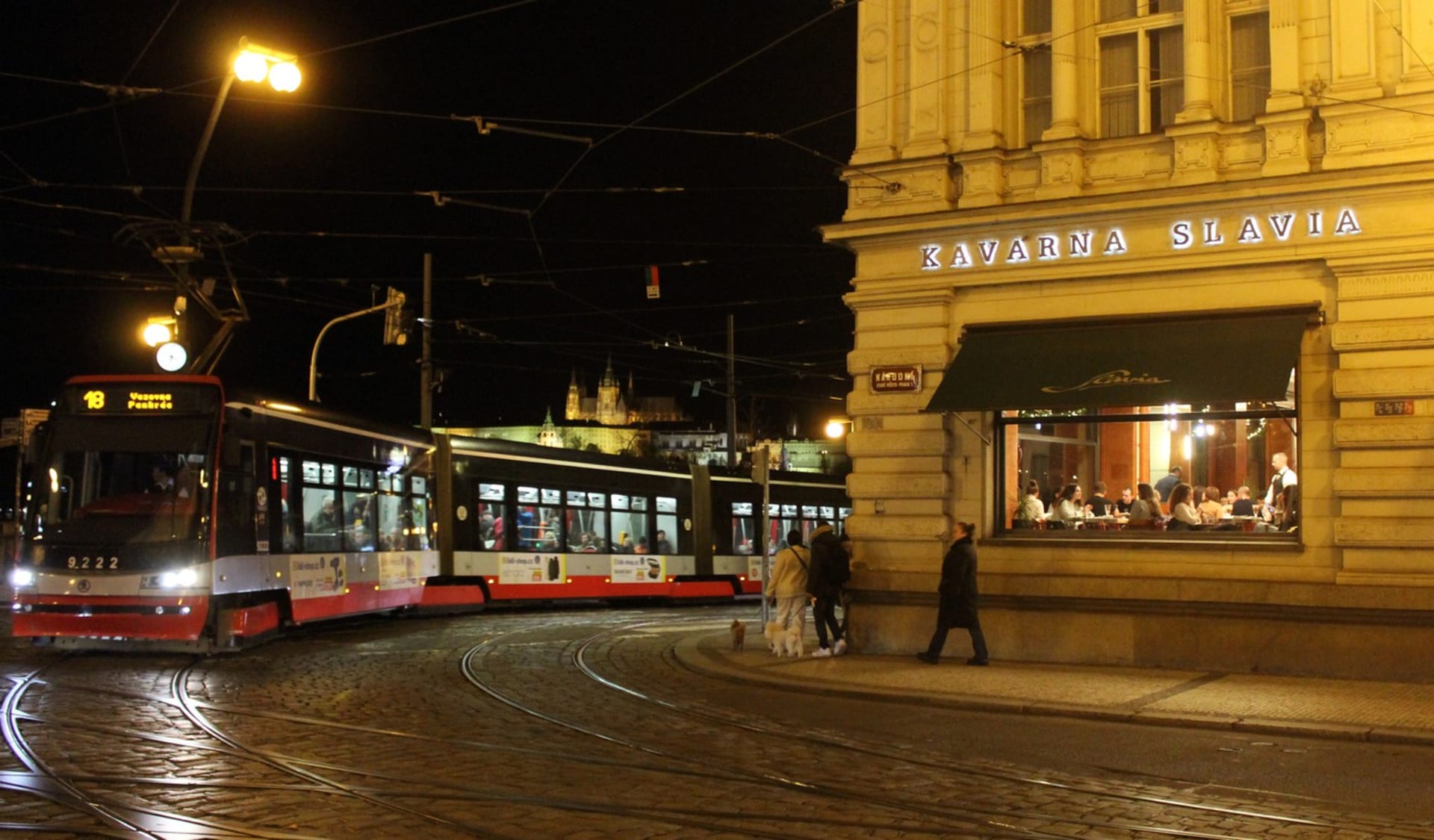 Tramvaj projíždí kolem kavárny Slavia na rohu Národní třídy a Smetanova nábřeží