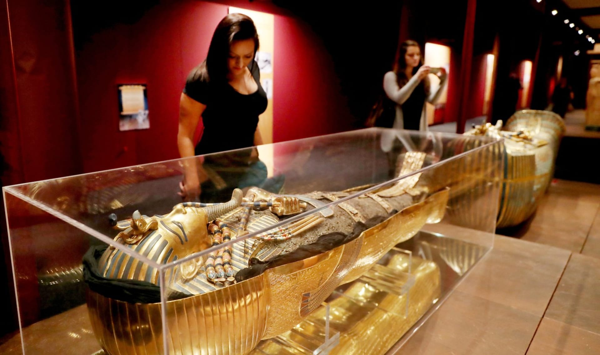Žena obdivuje repliku posmrtné masky faraona Tutanchamona - ilustrační foto.