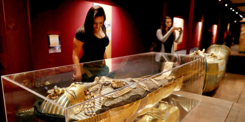 Žena obdivuje repliku posmrtné masky faraona Tutanchamona - ilustrační foto.
