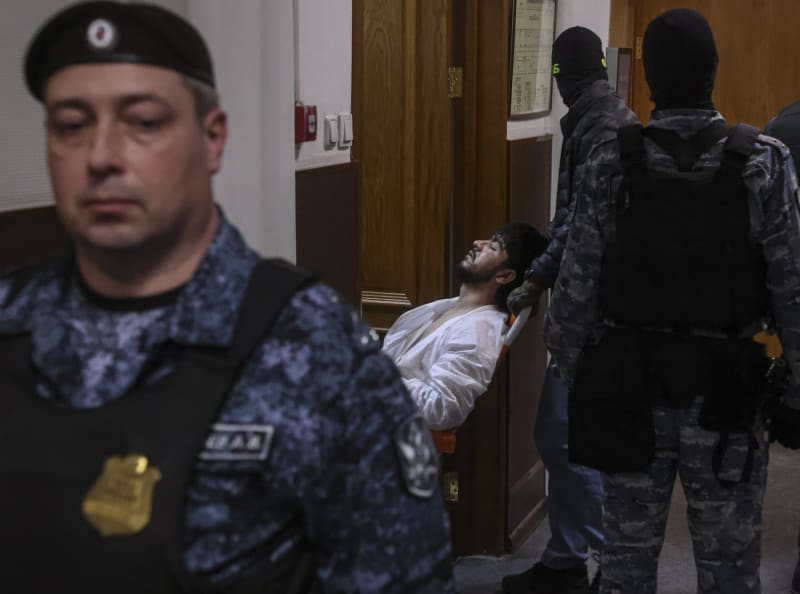 Obviněnou čtveřici z teroristického útoku na koncertní síň v Krasnogorsku přivezli policisté k soudu, podezřelí vykazovali známky fyzického násilí (24. 3. 2024). 