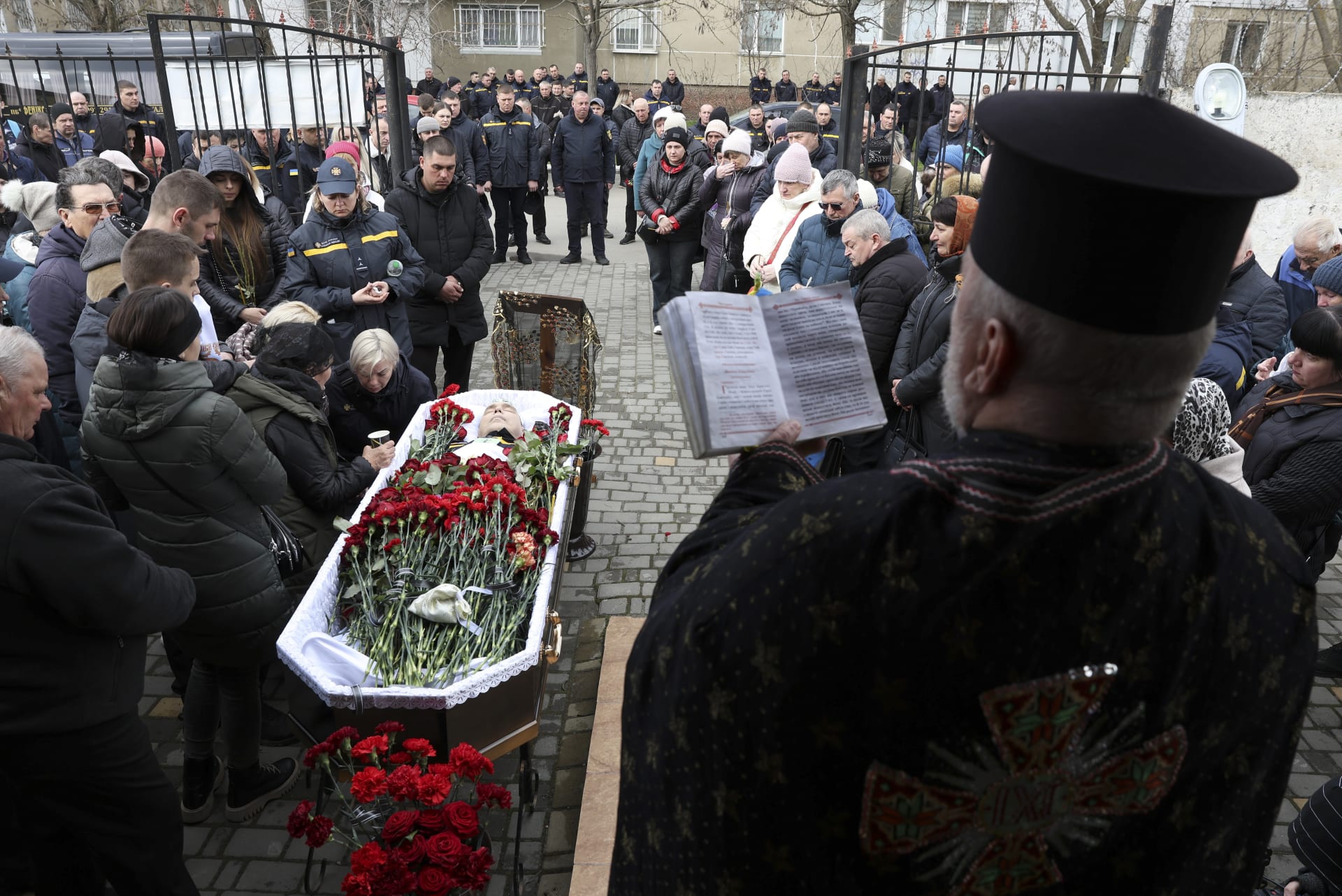 Členové rodiny Vitalije Alimova truchlí nad jeho tělem během pohřbu v ukrajinském Bilhorodu-Dnistrovském v pondělí 18. března 2024. Alimov. Hasič, byl zabit při ruském útoku na Oděsu v pátek 15. března.