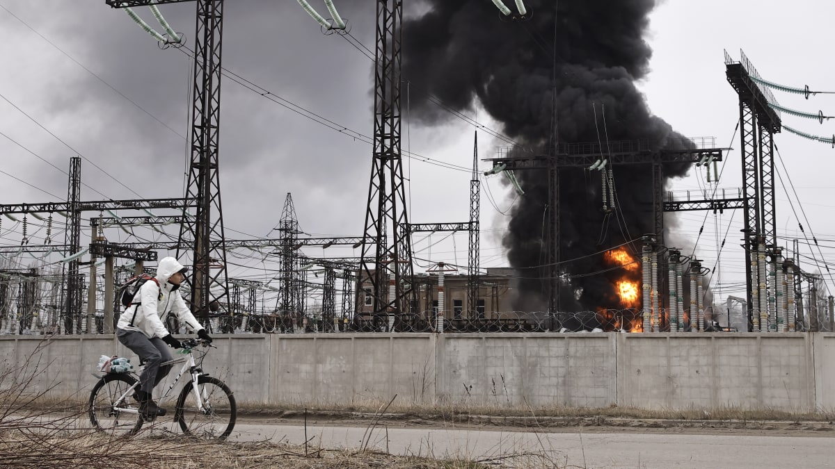 Muž projíždí na kole kolem elektrárny po ruském útoku v Charkově na Ukrajině, pátek 22. března 2024.
