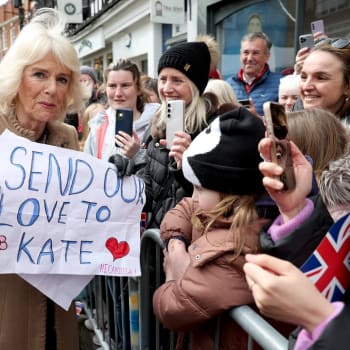 Britská královna Camilla drží transparent s nápisem: „Posíláme naši lásku Kate“. 