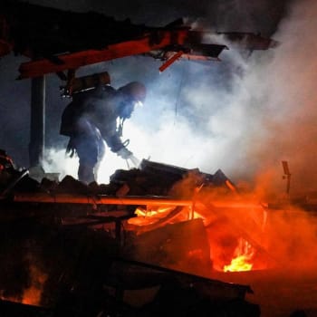 Ukrajinští hasiči likvidují následky útoku dronu