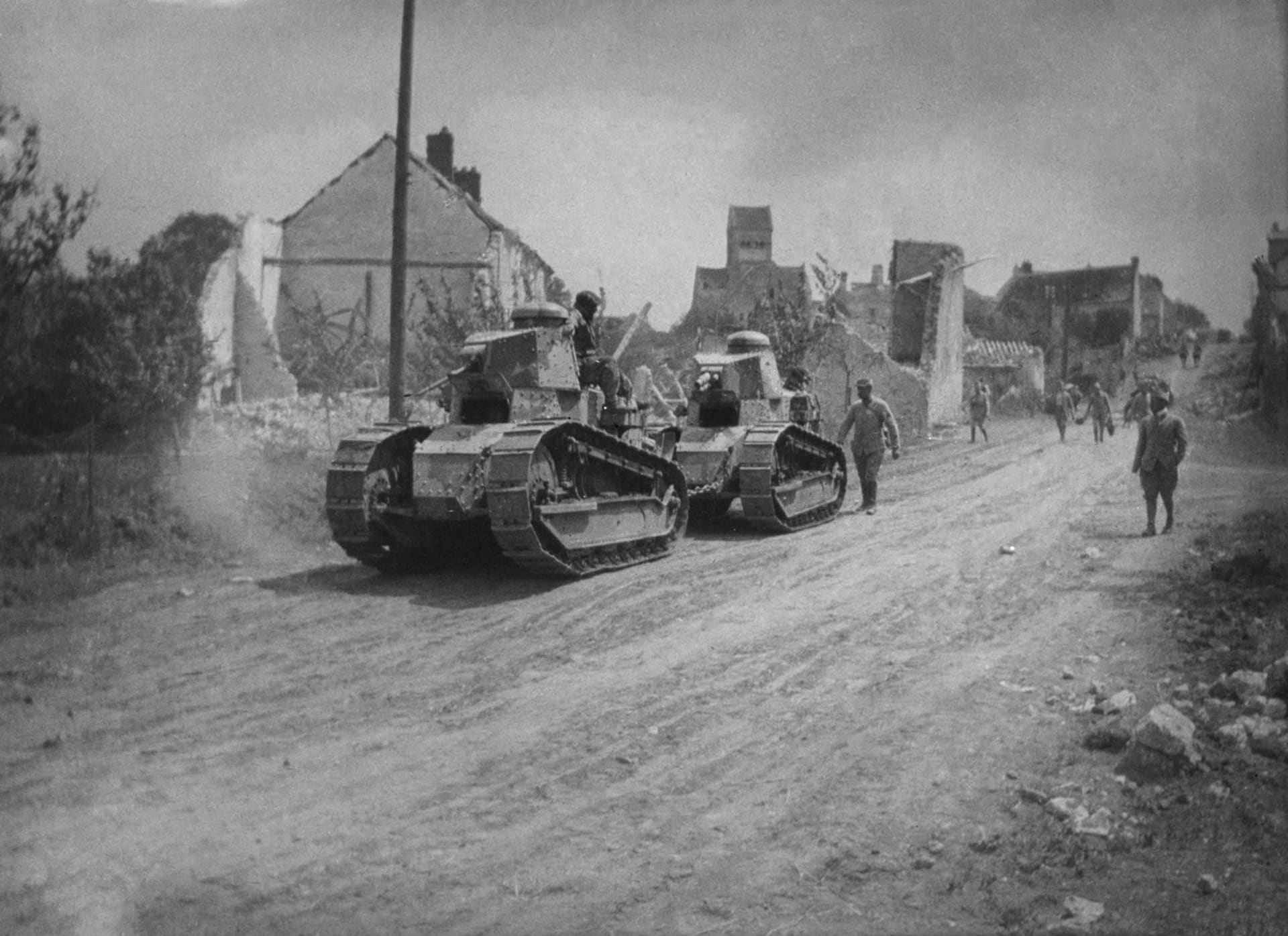 Dva Renaulty FT-17 plostupují zničenou vesnicí ve Francii (1918)