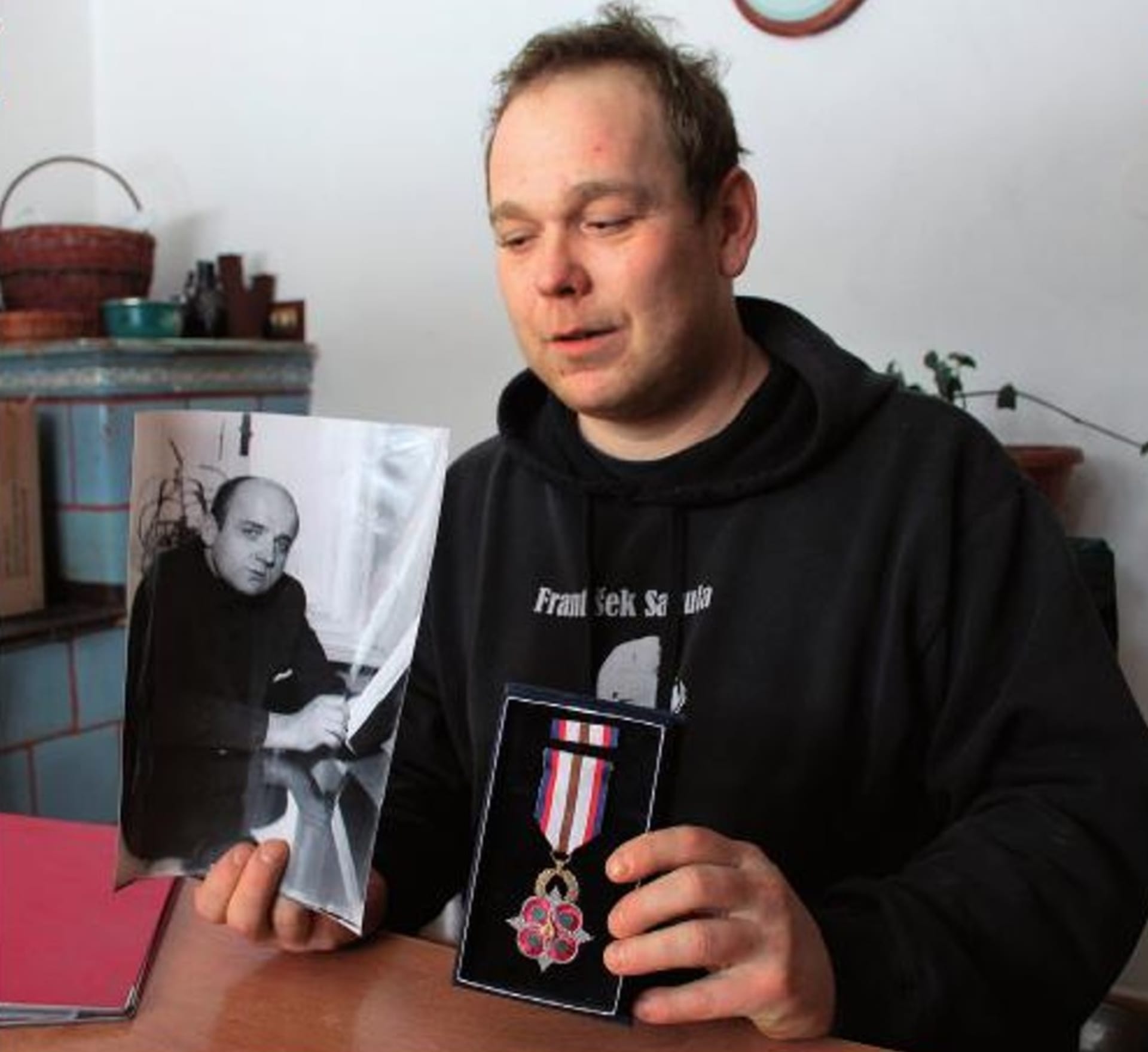 Vnuk Evžena Plocka se snímkem svého dědy. A s vyznamenáním, které oběť dostala in memoriam.