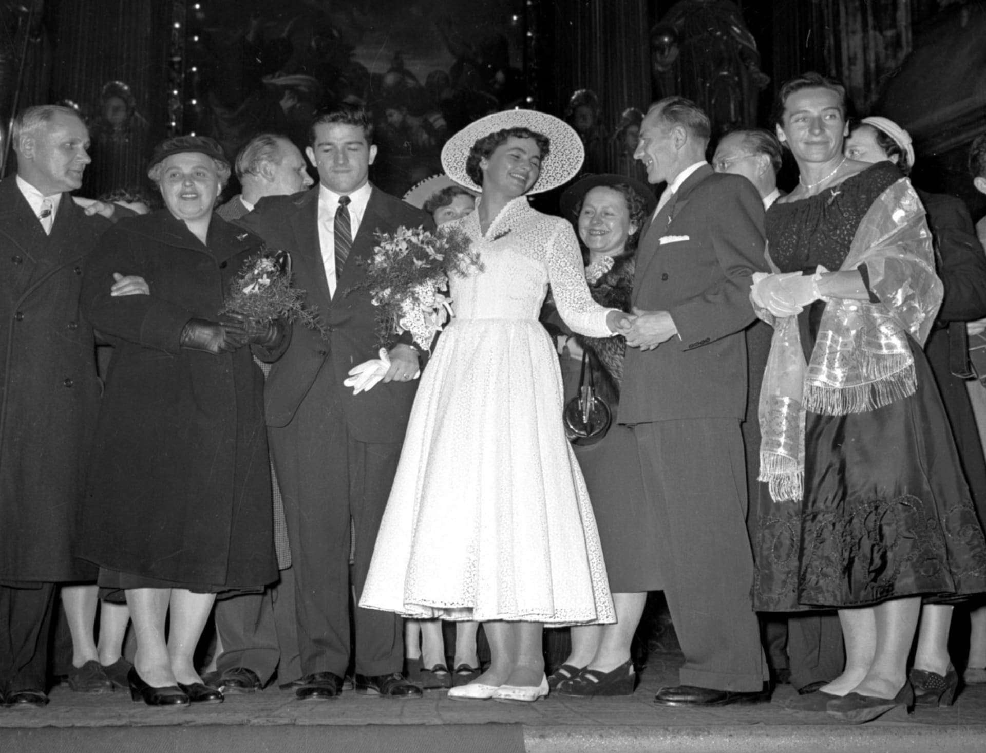 Snímek ze svatebního obřadu Olgy Fikotové a Harolda Connollyho v kostele sv. Salvátora. Emil Zátopek a Dana Zátopková blahopřejí novomanželům.